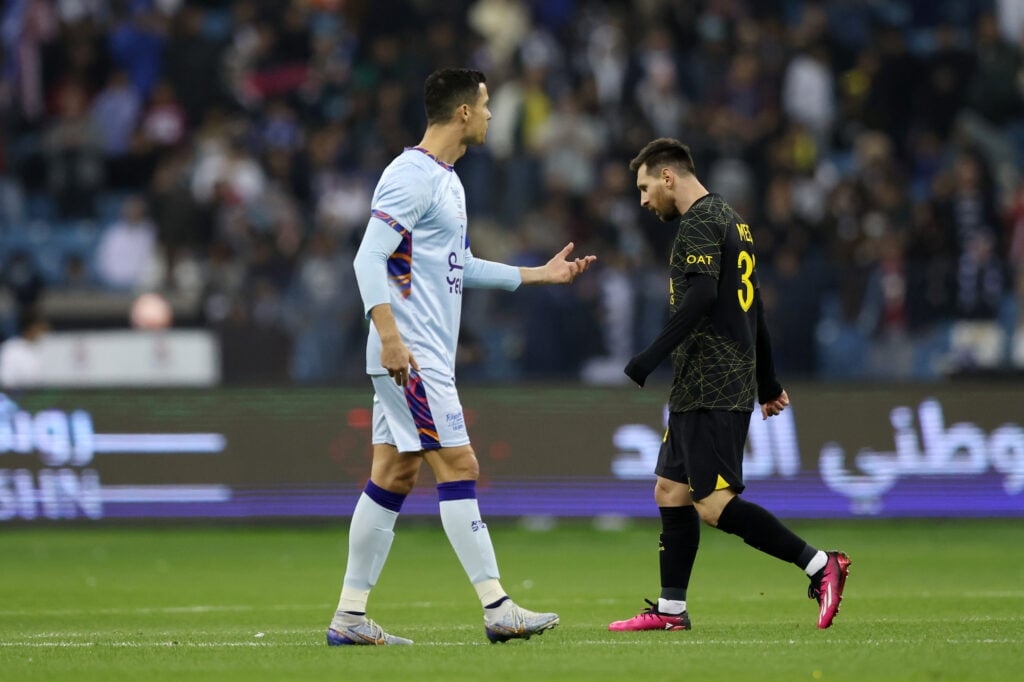 Lionel Messi of Paris Saint-Germain walks past Cristiano Ronaldo of Riyadh XI after scoring the side's first goal during the Winter Tour 2023 friendly between Paris Saint-Germain and Riyadh XI at King Fahd International Stadium.