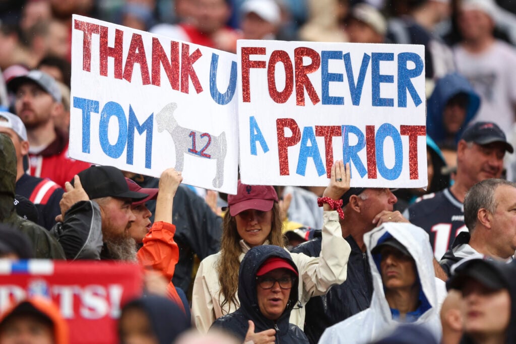 New England Patriots fans hold signs for former quarterback Tom Brady during the second quarter of an NFL football game against the Philadelphia Eagles at Gillette Stadium on September 10, 2023 in Foxborough, Massachusetts.