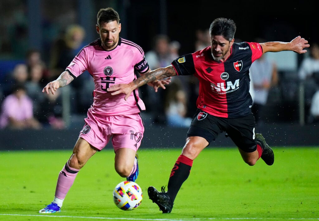 Lionel Messi #10 of Inter Miami CF competes for the ball with Pablo Pérez #8 of Newell's Old Boy during the first half of a friendly match at DRV PNK Stadium on February 15, 2024.