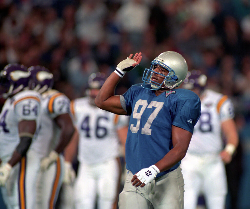Linebacker Tracy Scroggins #97 of the Detroit Lions signals to fans to cheer louder during a game against the Minnesota Vikings at the Pontiac Silverdome on December 17, 1994 in Pontiac, Michigan.