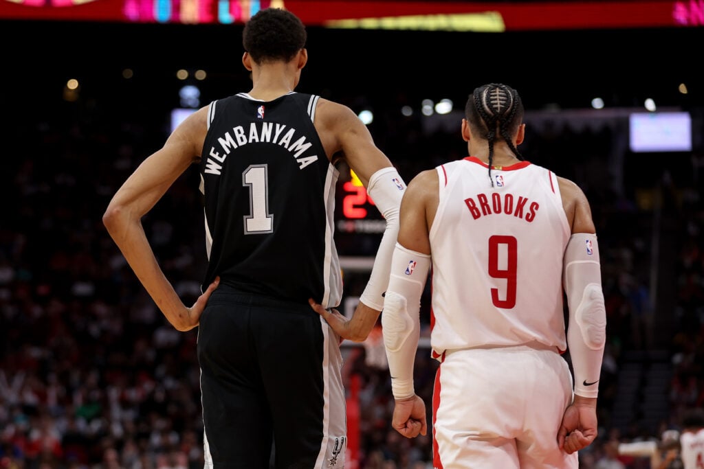 Victor Wembanyama #1 of the San Antonio Spurs and Dillon Brooks #9 of the Houston Rockets stand on the court in the second half at Toyota Center on March 05, 2024 in Houston, Texas.