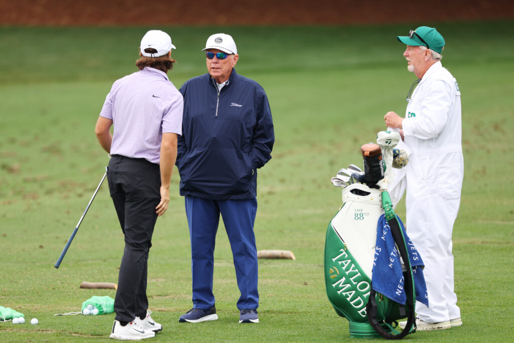 Tommy Fleetwood of England speaks with coach Butch Harmon during a practice round prior to the 2024 Masters Tournament