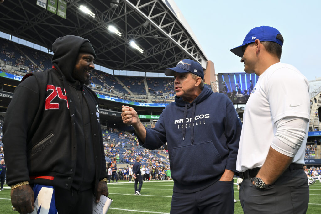 Retired NFL player, Marshawn Lynch, head coach Sean Payton of the Denver Broncos, and head coach Mike Macdonald of the Seattle Seahawks meet before the game at Lumen Field on September 08, 2024 in Seattle, Washington. The Seahawks defeated the Broncos 26-20.