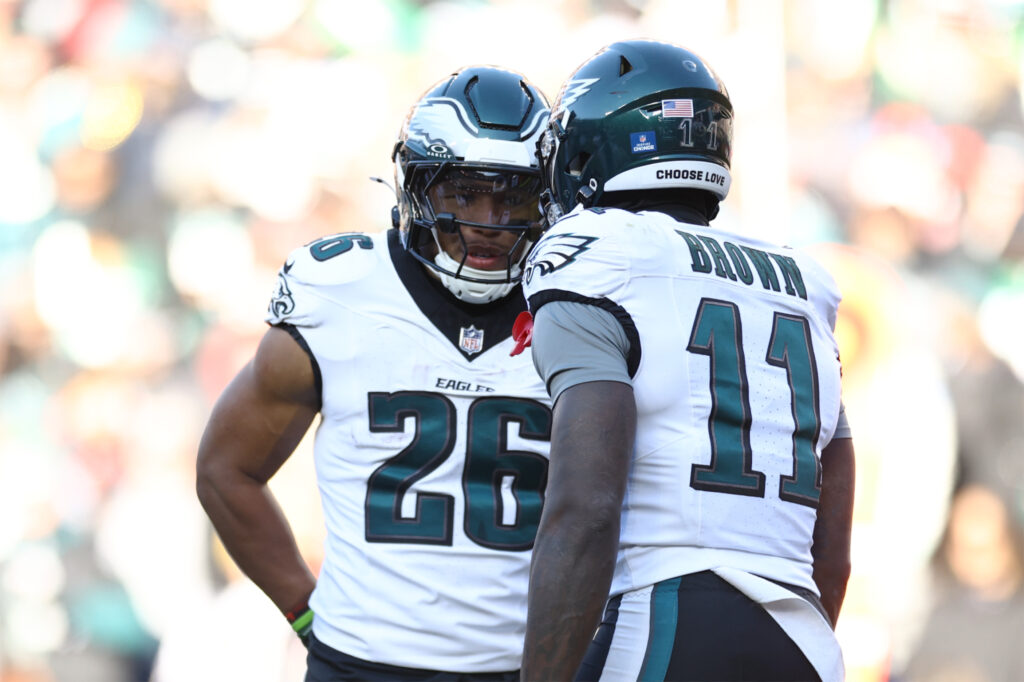 Saquon Barkley #26 and A.J. Brown #11 of the Philadelphia Eagles speak against the Washington Commanders at Northwest Stadium.