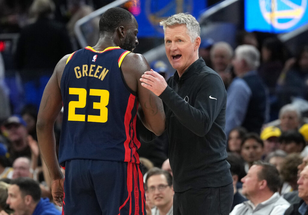 Head coach Steve Kerr of the Golden State Warriors talks with his player Draymond Green #23 during a break in the action against the Sacramento Kings in the fourth quarter at Chase Center.