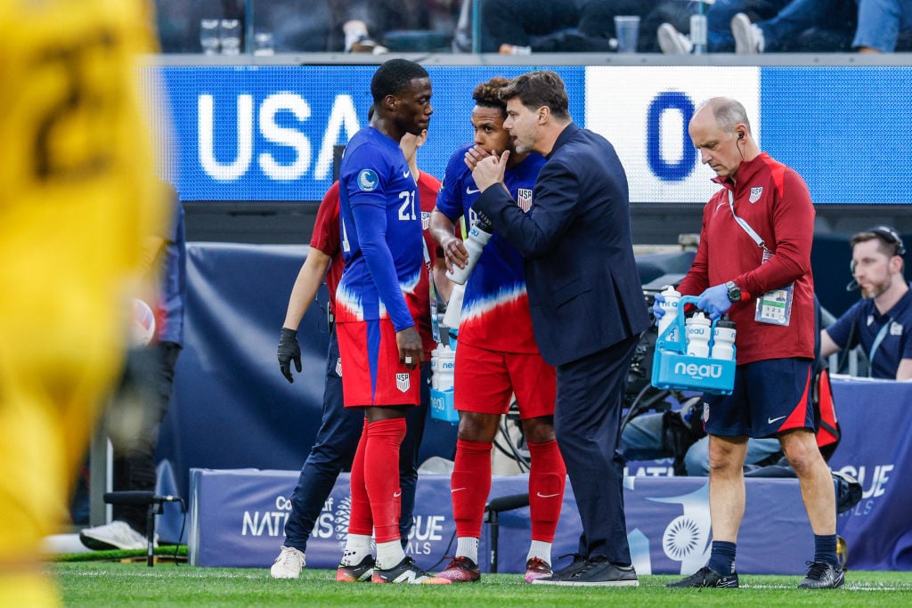 United States head coach Mauricio Pochettino talks with Timothy Weah #21 and Weston McKennie #8 of the United States during the second half of a CONCACAF Nations League semifinal match against Panama at SoFi Stadium.