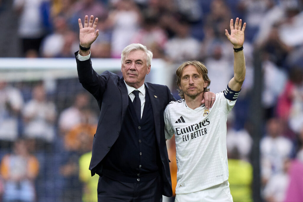 Carlo Ancelotti and Luka Modric wave, arm in arm