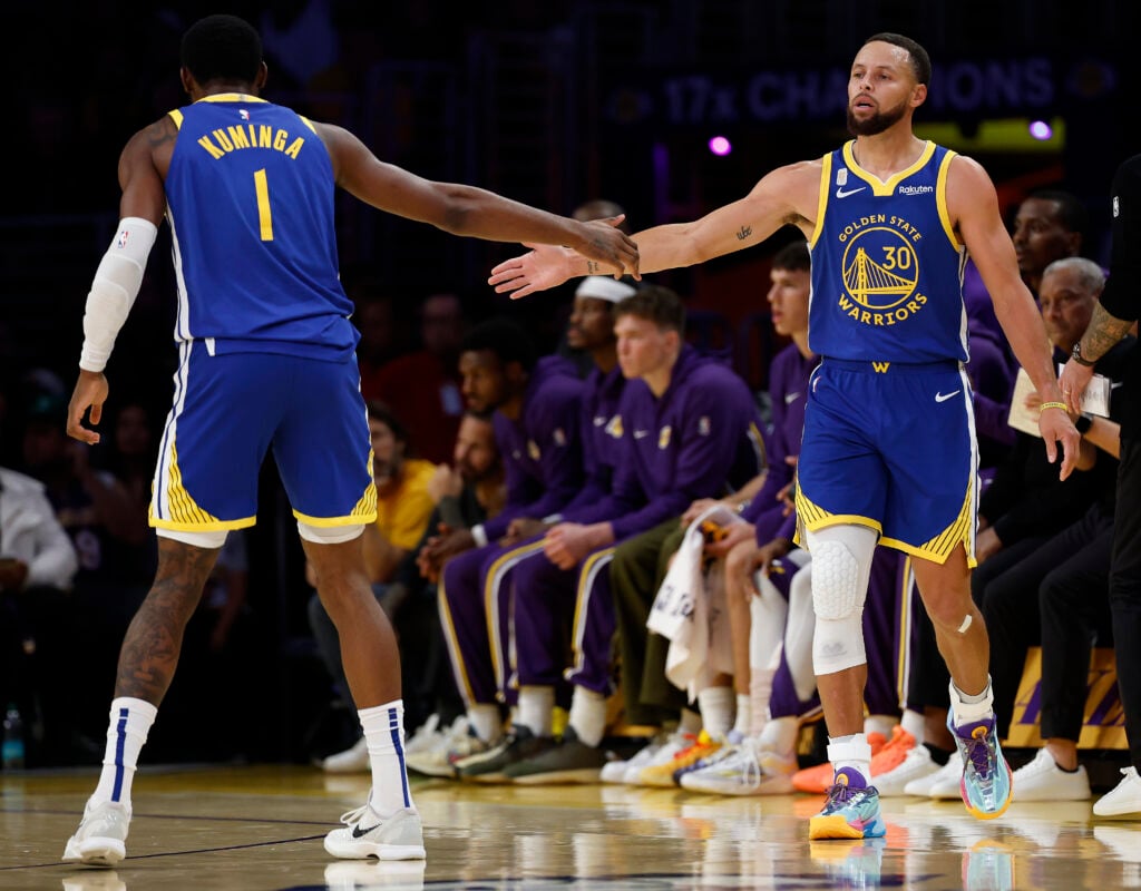 Stephen Curry #30 and Jonathan Kuminga #1 of the Golden State Warriors shake hands in the first quarter of the game against the Los Angeles Lakers at Crypto.com Arena on October 21, 2025 in Los Angeles, California.