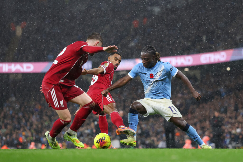 Jeremy Doku of Manchester City battles for possession with Ryan Gravenberch and Conor Bradley of Liverpool during the Premier League match between Manchester City and Liverpool at Etihad Stadium on November 09, 2025 in Manchester, England.