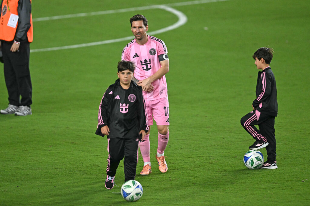 Inter Miami's Argentine forward #10 Lionel Messi (L) greets two of his children as he celebrates his team's victory in the Major League Soccer (MLS) Eastern Conference final football match between Inter Miami and New York City FC at Chase Stadium.