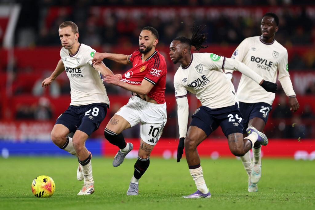 Matheus Cunha of Manchester United and Tomas Soucek of West Ham United and Aaron Wan-Bissaka of West Ham United during the Premier League match between Manchester United and West Ham United at Old Trafford on December 04, 2025 in Manchester, England.