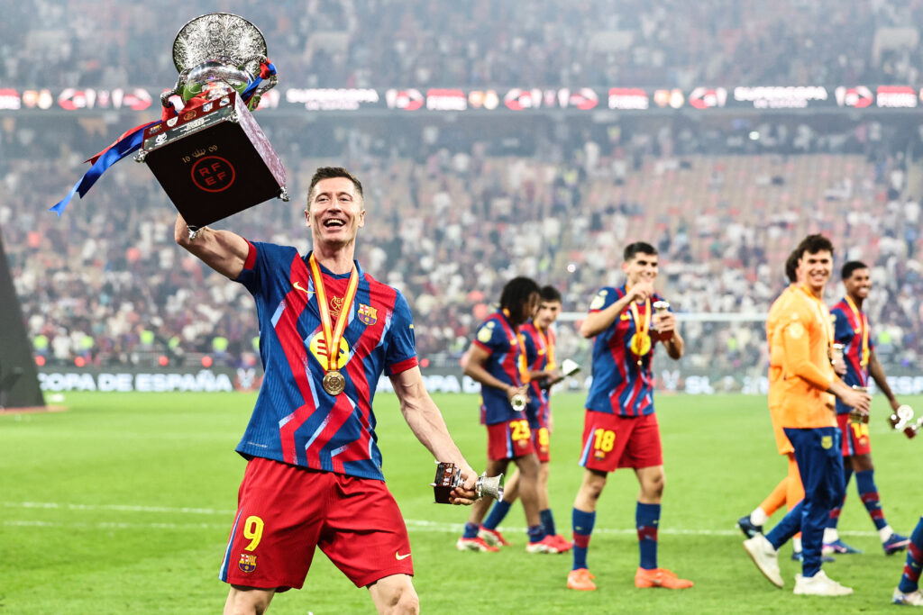 Barcelona's Polish forward #09 Robert Lewandowski raises the trophy as he celebrates after winning the Spanish Super Cup final football match between FC Barcelona and Real Madrid.