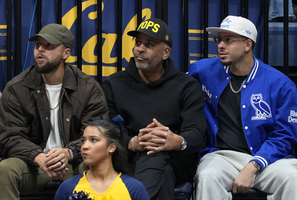 Stephen Curry #30, (L) and brother Seth Curry #31 of the Golden State Warriors (R) sit with their father Dell Curry "POPS" courtside as the Duke Blue Devils play the California Golden Bears in an NCAA men's basketball game at Haas Pavilion.