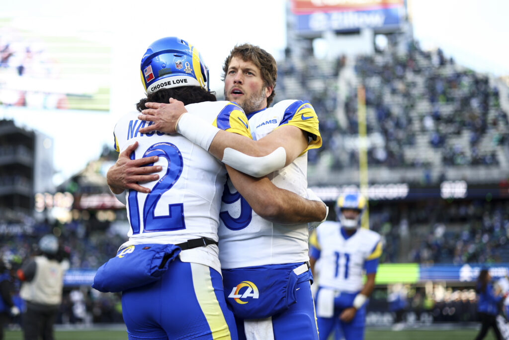 Matthew Stafford #9 and Puka Nacua #12 of the Los Angeles Rams hug prior to the NFC Championship NFL football game against the Seattle Seahawks, at Lumen Field.