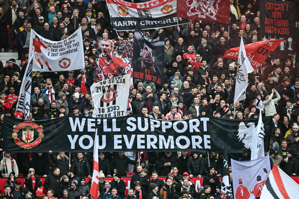 Supporters display banners before the start of the English Premier League football match between Manchester United and Fulham at Old Trafford in Manchester, north west England, on February 1, 2026.