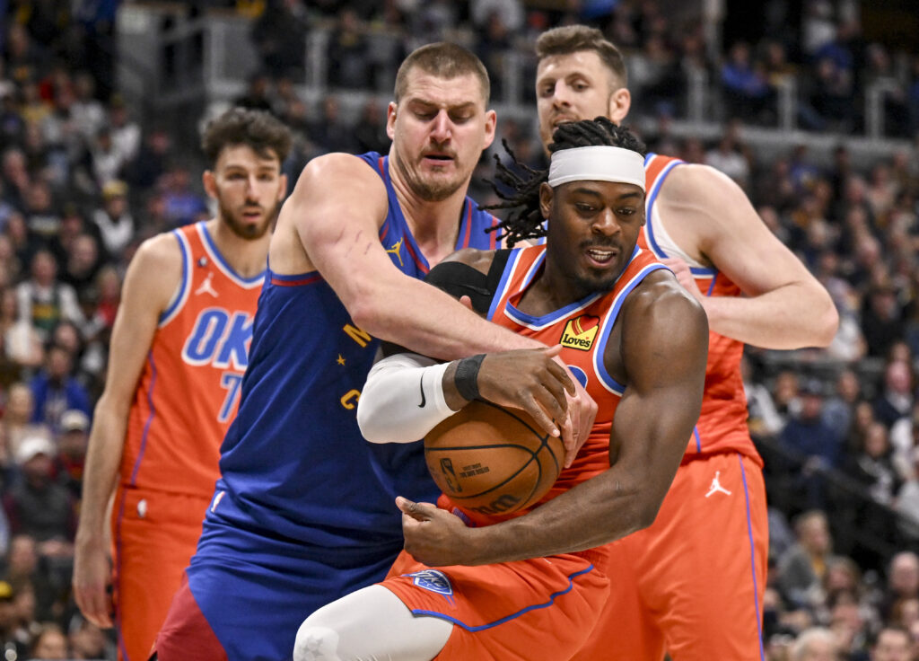Nikola Jokic (15) of the Denver Nuggets ties up Luguentz Dort (5) of the Oklahoma City Thunder during the fourth quarter of the OKC's 121-111 win at Ball Arena in Denver, Colorado on Sunday, February 1, 2026.
