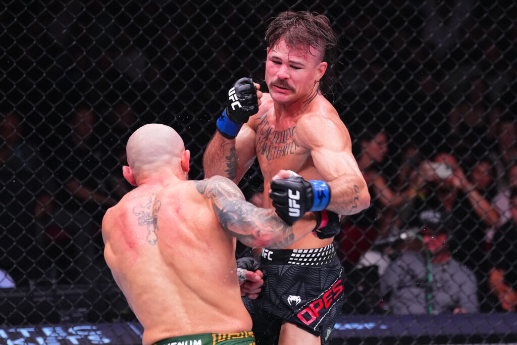 Diego Lopes of Brazil battles Alexander Volkanovski of Australia in the UFC featherweight championship fight during the UFC 325 event at Qudos Bank Arena.