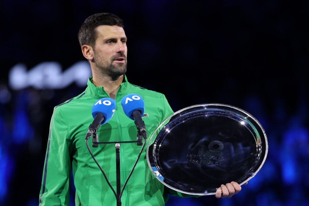 Runner-up Novak Djokovic of Serbia speaks with the finalist plaque at the presentation ceremony after the Men's Singles Final against Carlos Alcaraz of Spain during day 15 of the 2026 Australian Open