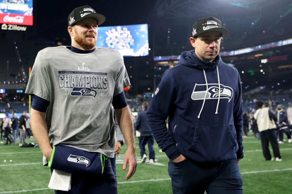 Sam Darnold #14 and offensive coordinator Klint Kubiak of the Seattle Seahawks celebrate after defeating the Los Angeles Rams 31-27 in the NFC Championship game at Lumen Field.