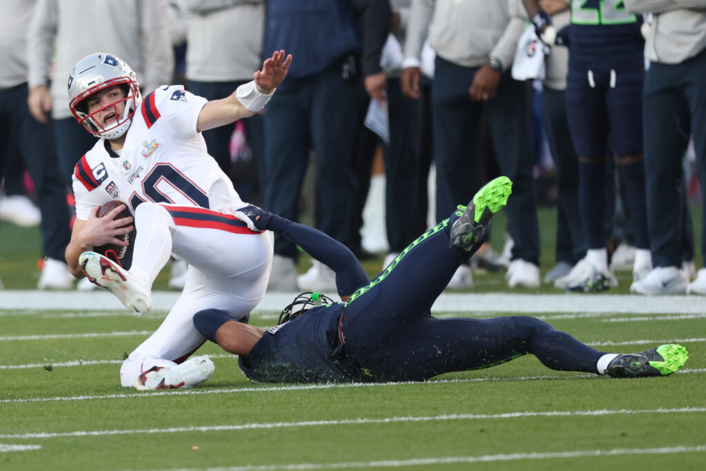 Drake Maye #10 of the New England Patriots is sacked by Nick Emmanwori #3 of the Seattle Seahawks during the first quarter of Super Bowl LX