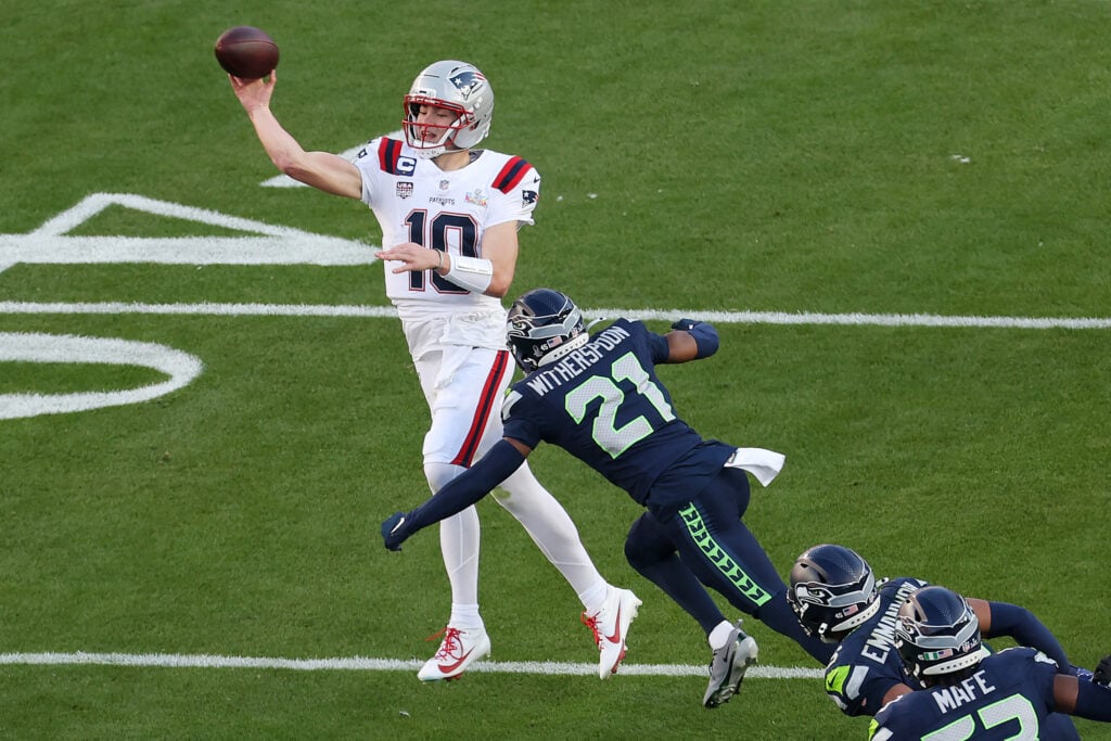 Drake Maye #10 of the New England Patriots throws under pressure from Devon Witherspoon #21 of the Seattle Seahawks during the first quarter in Super Bowl LX