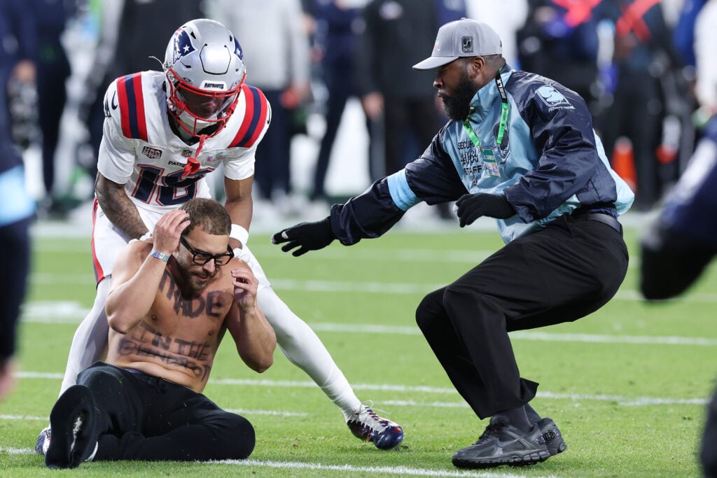 Kyle Williams #18 of the New England Patriots and a security guard tackle a fan who ran onto the field during the Super Bowl LX between the Seattle Seahawks and the New England Patriots at Levi's Stadium on February 08, 2026 in Santa Clara, California.