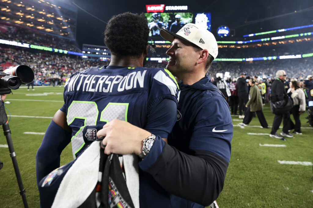 Devon Witherspoon #21 of the Seattle Seahawks and Mike MacDonald of the Seattle Seahawks celebrate after defeating the New England Patriots in Super Bowl LX at Levi's Stadium.