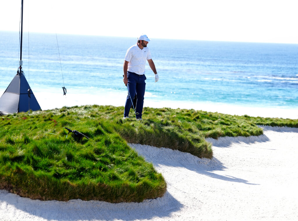 Scottie Scheffler looks where to land his ball when getting ready to chip out of the rough on the 10th hole on February 12, 2026, during the first round of the PGA AT&T Pebble Beach Pro-Am