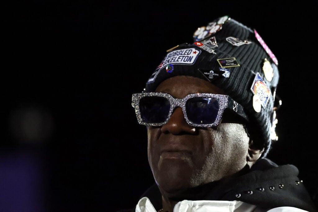 Flavor Flav looks on as he watches the medal ceremony for the Women's Monobob Bobsleigh on day ten of the Milano Cortina 2026 Winter Olympic games at Cortina Sliding Centre on February 16, 2026.
