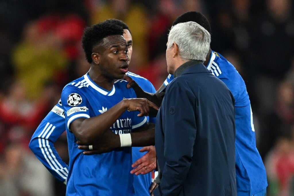 Vinicius Junior of Real Madrid speaks to Jose Mourinho, Head Coach of Benfica, after a clash with Gianluca Prestianni during the UEFA Champions League 2025/26 League Knockout Play-off First Leg match between SL Benfica and Real Madrid C.F.