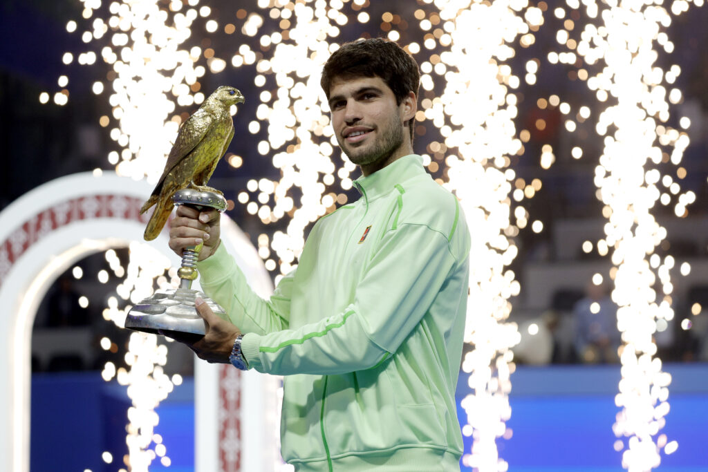 Carlos Alcaraz of Spain celebrates with the trophy after winning his men's singles final match against Arthur Fils of France at the Qatar ExxonMobil Open at Khalifa International Tennis and Squash Complex on February 21, 2026 in Doha, Qatar.