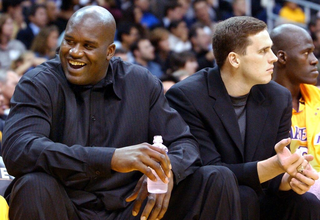 Los Angeles Lakers' injured center Shaquille O'Neal (L) sits on the bench with injured teammate Mark Madsen during the first quarter of the season-opener against the San Antonio Spurs.