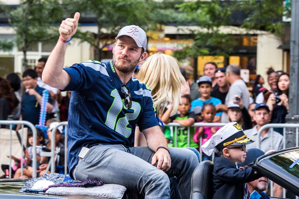 Actor Chris Pratt and son Jack Pratt ride in the Seafair Torchlight Parade Grand Marshal vehicle.