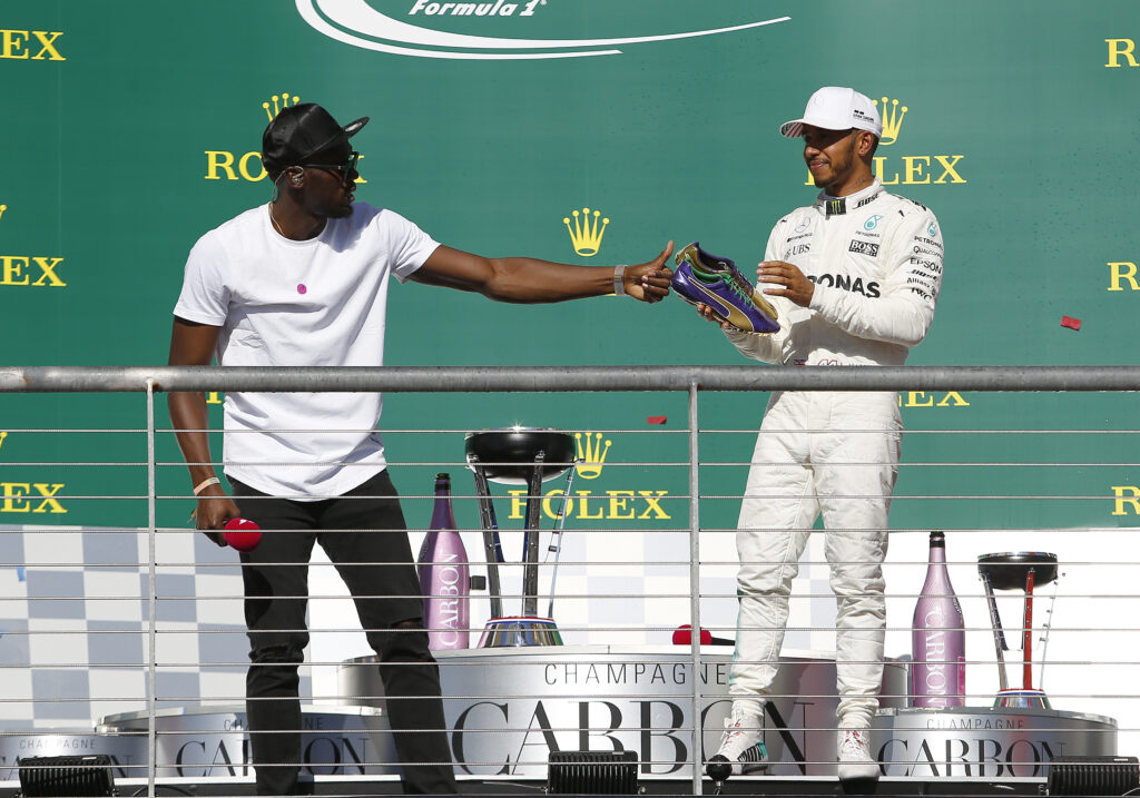 Usain Bolt and Lewis Hamilton celebrate on the 2017 F1 United States Grand Prix podium