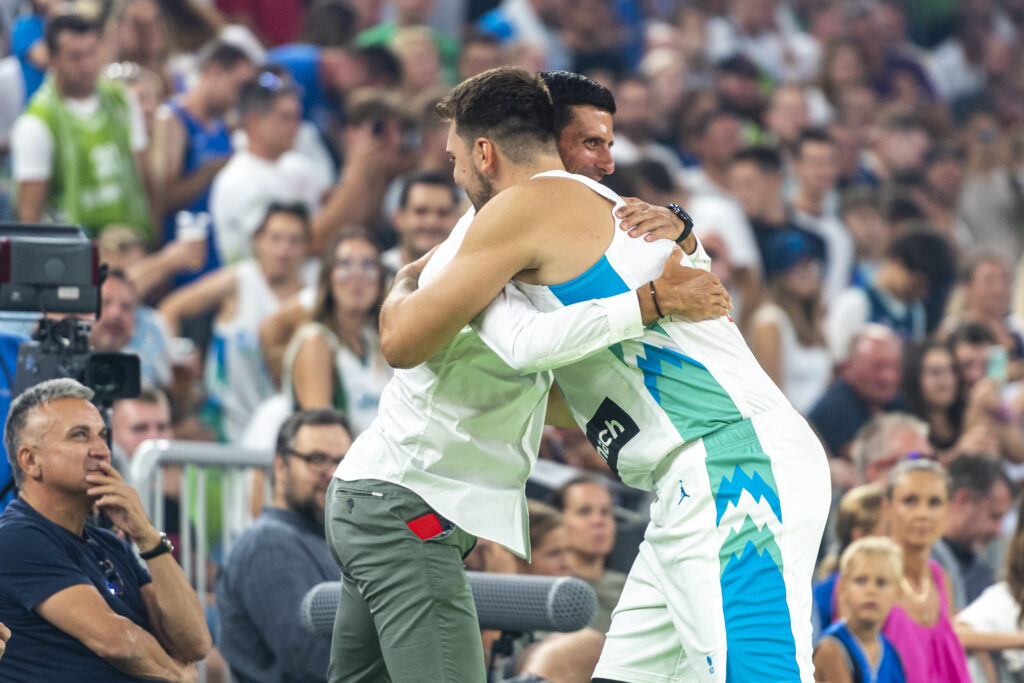 Luka Doncic of Slovenia embraces Serbian tennis player Novak Djokovic during the basketball friendly match between Slovenia and Serbia in Arena Stozice, on August 17, 2022 in Ljubljana, Slovenia.