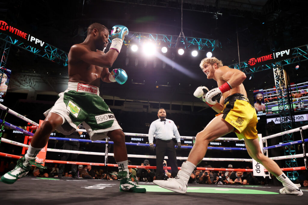 Floyd Mayweather (green shorts) exchanges blows with Logan Paul during their contracted exhibition boxing match at Hard Rock Stadium on June 06, 2021 in Miami Gardens, Florida.