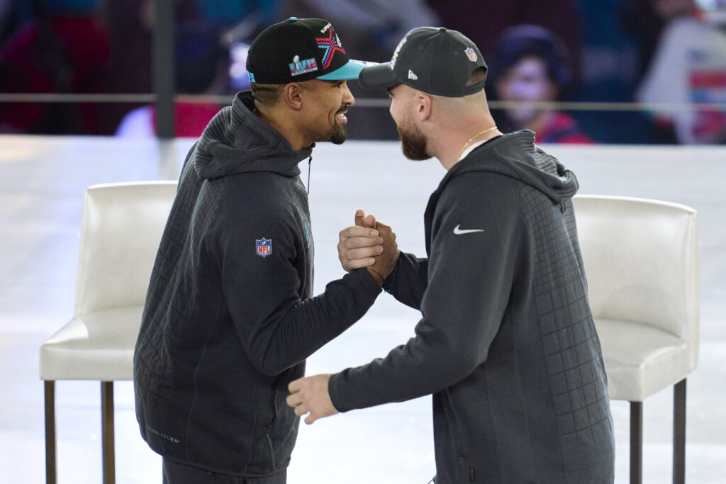 Jalen Hurts #1 of the Philadelphia Eagles hugs Travis Kelce #87 of the Kansas City Chiefs at Footprint Center.