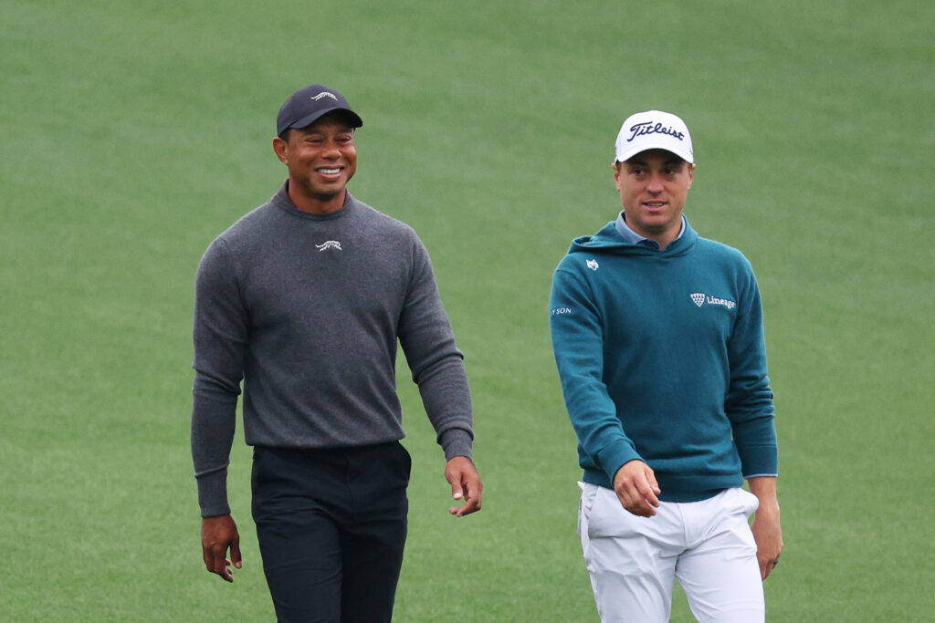 Tiger Woods and Justin Thomas walk down the first fairway during a practice round prior to the 2024 Masters