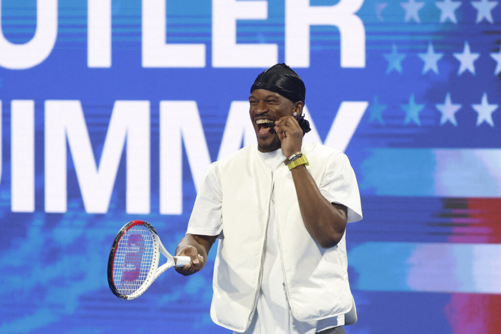 US basketball player Jimmy Butler of the Golden State Warriors jokes with Spain's Carlos Alcaraz (not pictured) after his men's singles match at the ATP Qatar Open tennis tournament.