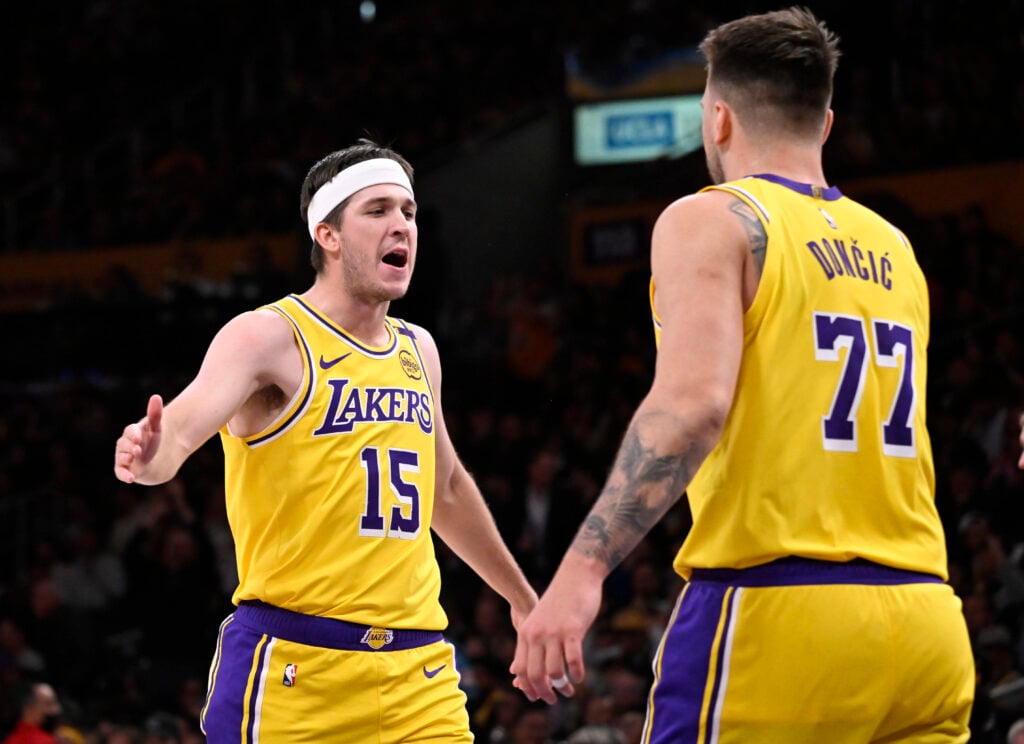 Austin Reaves #15 of the Los Angeles Lakers high fives teammate Luka Doncic #77 of the Los Angeles Lakers after a three point basket against the Denver Nuggets.