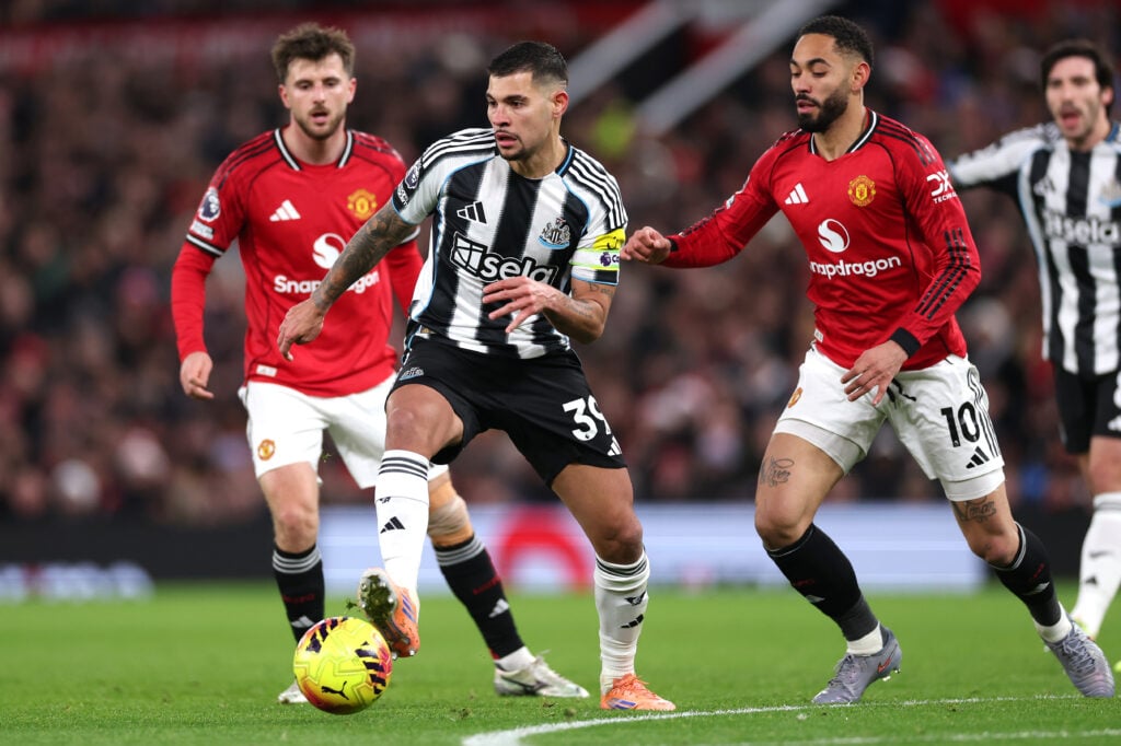 Bruno Guimaraes of Newcastle United in action watched by Matheus Cunha of Manchester United during the Premier League match between Manchester United and Newcastle United at Old Trafford on December 26, 2025 in Manchester, England.