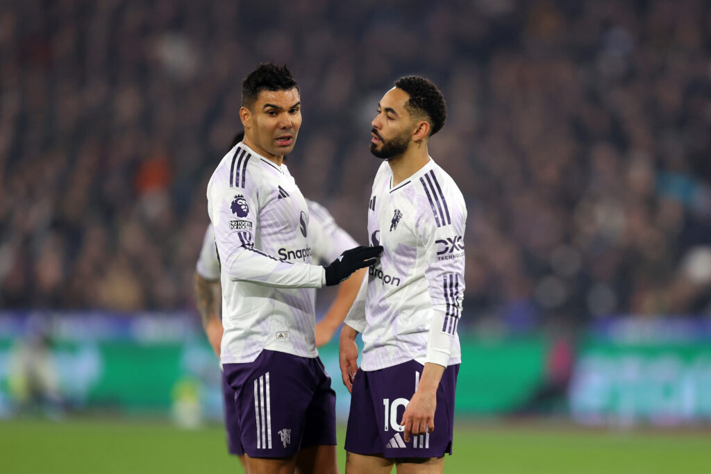 Casemiro speaks to Matheus Cunha of Manchester United during the Premier League match between West Ham United and Manchester United at London Stadium.