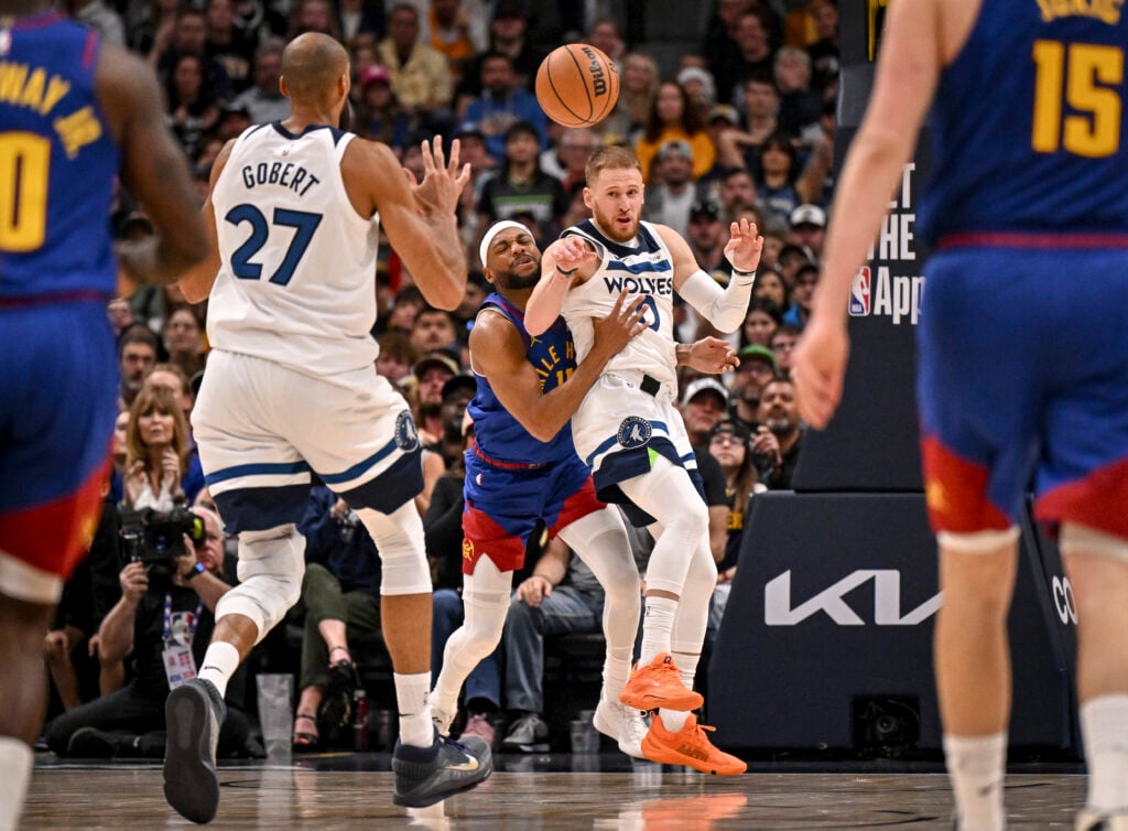 Donte DiVincenzo (0) of the Minnesota Timberwolves passes to Rudy Gobert (27) as Bruce Brown (11) of the Denver Nuggets defends during the fourth quarter of the Timberwolves' 117-108 win at Ball Arena in Denver, Colorado on Sunday, March 1, 2026.