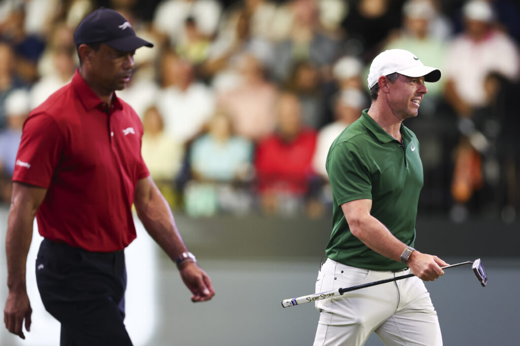 Rory McIlroy of Boston Common Golf and Tiger Woods of Jupiter Links GC walk alongside each other during a match at SoFi Center