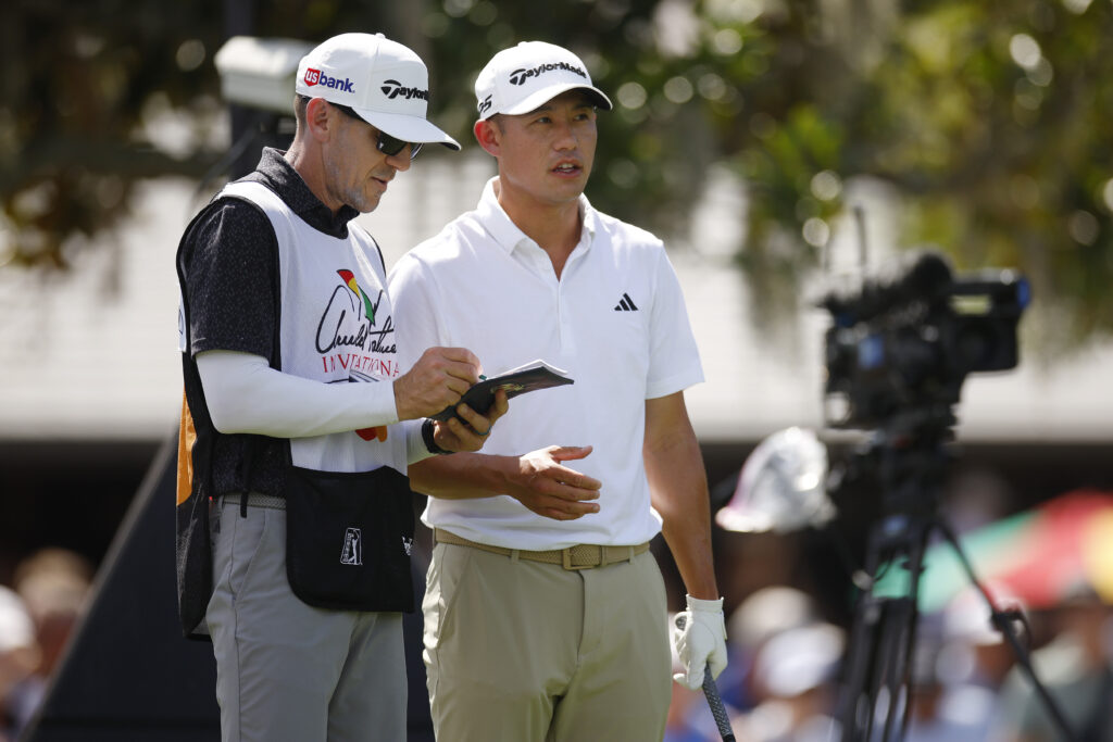 Collin Morikawa of the United States talks with his caddie on the first hole during the second round of the Arnold Palmer Invitational