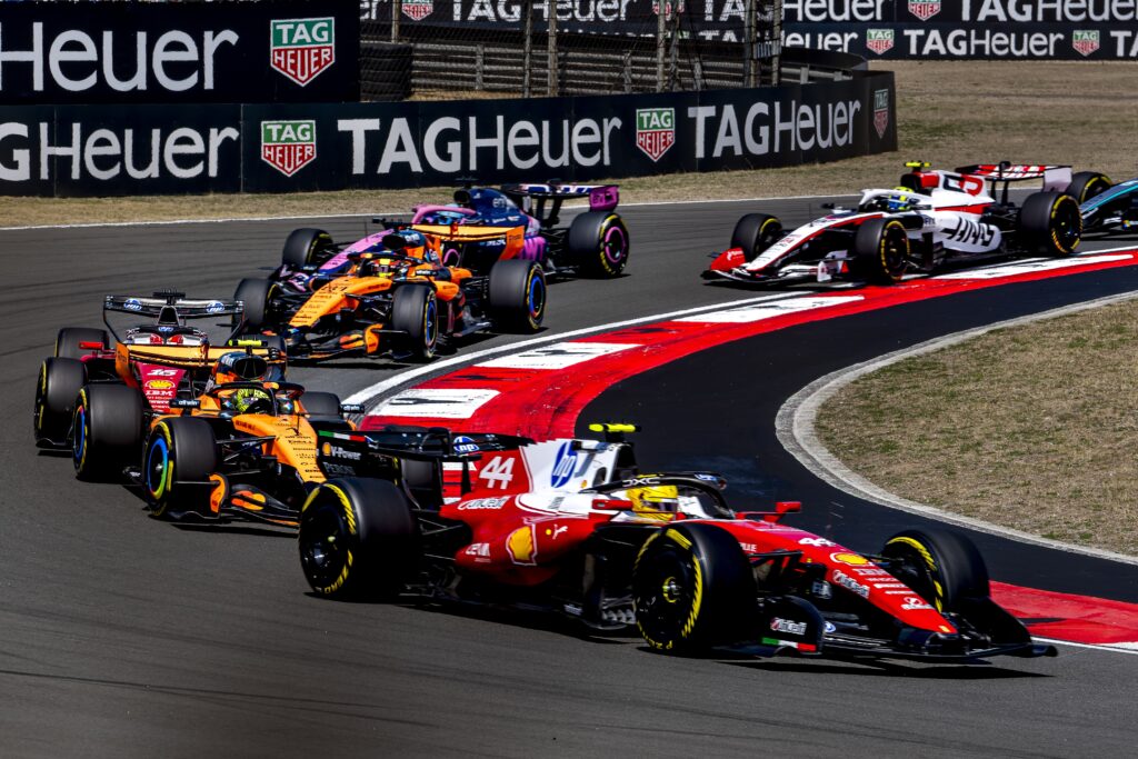 Lewis Hamilton's Ferrari leads from the McLaren of Lando Norris and several F1 cars at the start of the 2026 Chinese Grand Prix Sprint race
