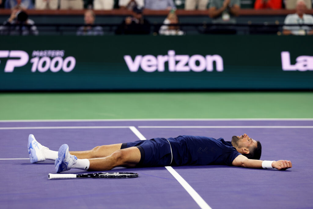 Novak Djokovic of Serbia falls to the court with exhaustion against Jack Draper of Great Britain in their fourth round match of the BNP Paribas Open at Indian Wells Tennis Garden.
