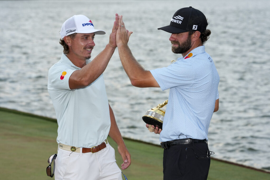 Cameron Young high-fives his caddie Kyle Sterbinsky during a trophy ceremony after winning THE PLAYERS Championship