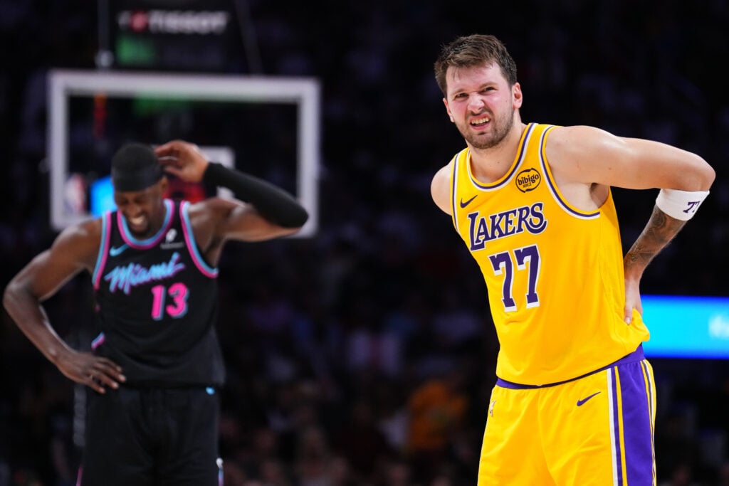 Luka Doncic #77 of the Los Angeles Lakers and Bam Adebayo #13 of the Miami Heat react after colliding during the third quarter at Kaseya Center.