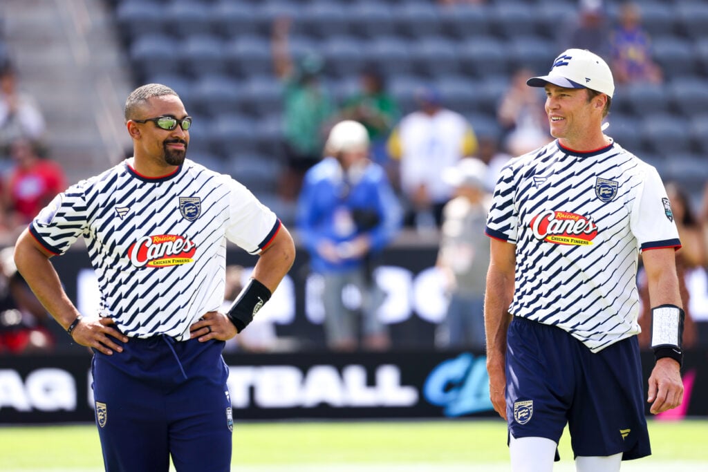 Jalen Hurts #1 and Tom Brady #12 of the Founders FFC look on before the Fanatics Flag Football Classic at BMO Stadium.